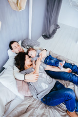 Obraz premium The mother ,father and son lie on the bed
