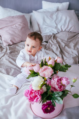 The tenderness boy with flowers sitting on the bed