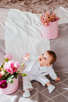 The tenderness boy with flowers sitting near bed