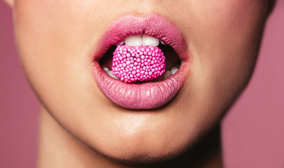 Beautiful pink lips with a piece of candy - obrazy, fototapety, plakaty