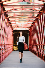 Young stylish girl walking on bridge