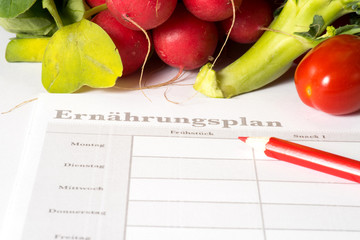Gemüse, ein Ernährungsplan und ein roter Stif
