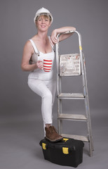 Worker wearing dungarees taking a tea break at her place of work