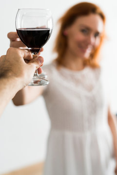 Person clanging glasses with woman