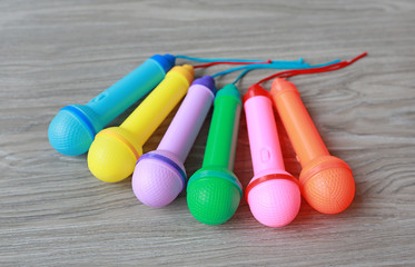Colorful plastic microphone on wood background, Children's toy
