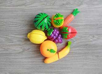 Plastic fruits on wood background, Children's toy