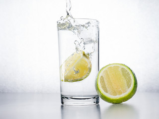 Glass of water with lime on white background.