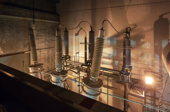 Giant insulators for switchgear in the powerhouse. Dark photo