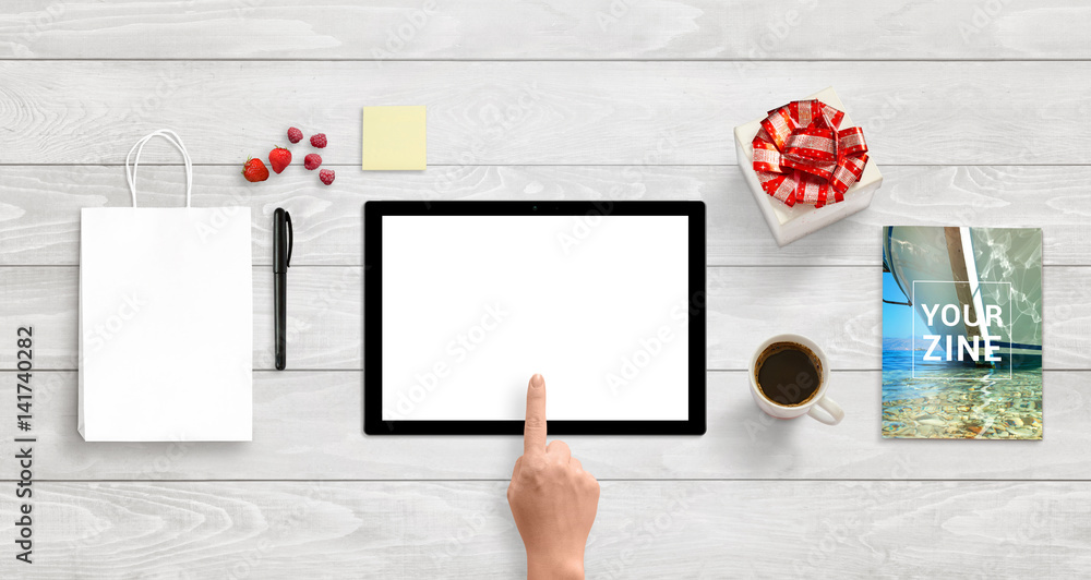 Poster Tablet with isolated white screen for app or responsive web site design presentation. Top view of white wooden desk. Bag, gift, magazine, note, coffee beside.