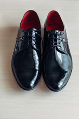 Black lacquer shoes stand on white table