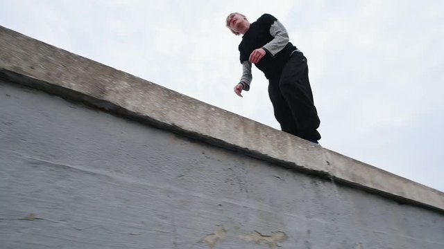 Urban city parkour - athlete tracer performs free-running in winter park