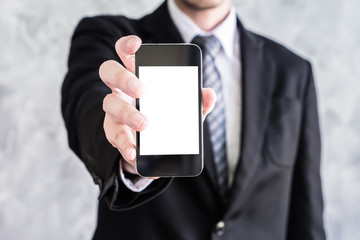 Close up of businessman holding smart phone on grunge background.