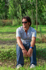 Fototapeta premium A handsome man with black glasses is sitting contemplating nature
