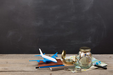 Jar with money for a travel, maps, passport, and other stuff for adventure