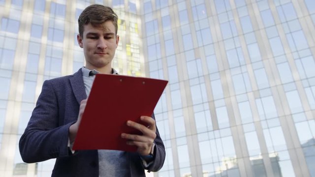 close up view of man with folder on the city street