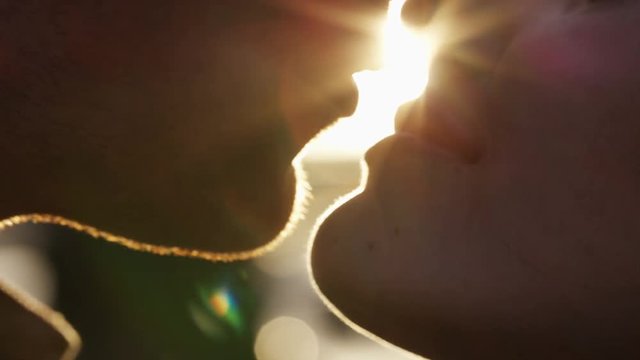 4K Close up of young couple kissing at sunset, in slow motion