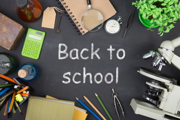 Education concept - books, microscope and Science inscription on the blackboard