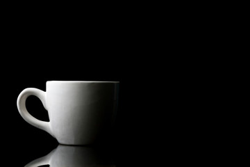 White cup on black background. Free space for text