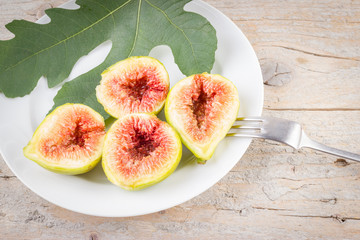 Ripe fresh cut figs on wooden background