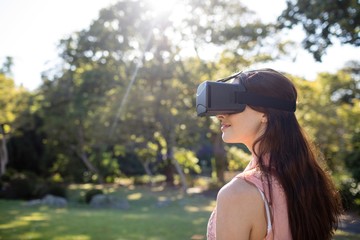 Fototapeta premium Woman using a VR headset in the park