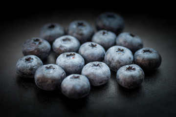 Natural looking blueberries on dark background. Selective focus.