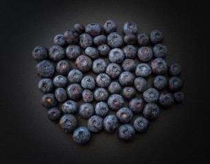 Natural looking blueberries on dark background. Top view. Selective focus in the middle.