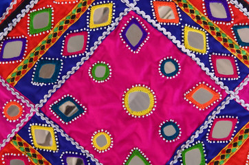lepo embroidery work on clothes stitching pieces of mirror, decorative beads and coins on clothes by Indian tribal banjara or lambadi people