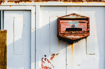 rusty steel mail box on iron door.