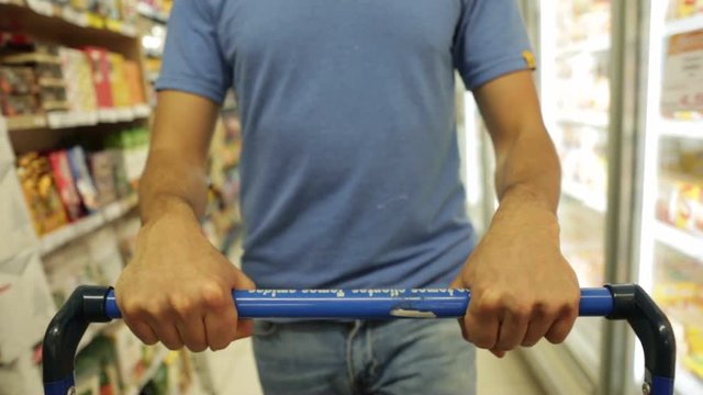 POV Of Man Walking With Cart At Grocery Store