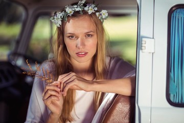 Portrait of woman with flower wreath sitting in campervan