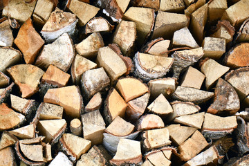 Natural wooden background, closeup of chopped firewood. Firewood stacked and prepared for winter Pile of wood logs. Chopped firewood on a stack.