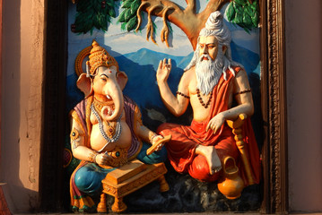 Wall art of Sage Vyasa dictating the story to help God Ganesha to write Hindu epic in temple