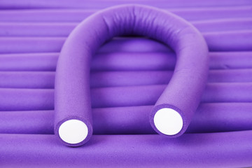 Violet hair curlers background. Tools for care of hair