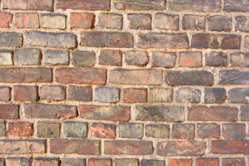 Naklejka premium Old empty uneven raw varied color brick wall