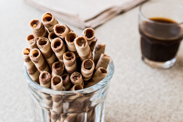Wafer Rolls in glass cup with coffee.