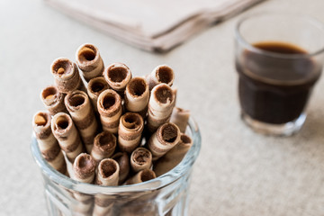 Wafer Rolls in glass cup with coffee.