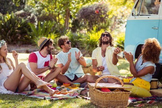 Group of friends having fun together near campervan