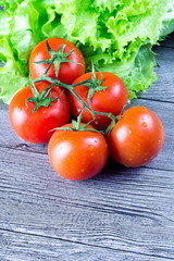 fresh tomatoes with salad on the gray wooden table