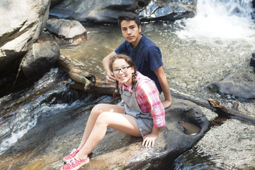Niños sobre roca de río