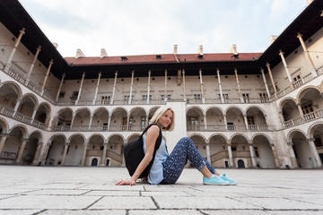 Female traveler on the background of Arcades in Wawel Castle in Cracow. Poland. Renaissance.