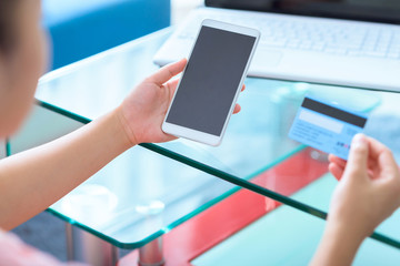People using credit card and smart phone paying online.