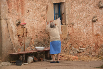 Plakat anciana lavando ropa