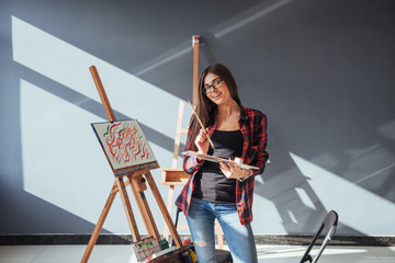 Pretty Pretty Girl artist paints on canvas painting on the easel.