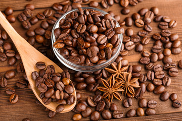 Coffee beans and cinnamon on a background of burlap. Roasted coffee beans background close up. Coffee beans pile from top with copy space for text. Seasoning. Spice. Cinnamon. Badian. Coffee house.