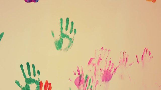 Closeup view of colorful child's handprints painted on the wall. 4k shot