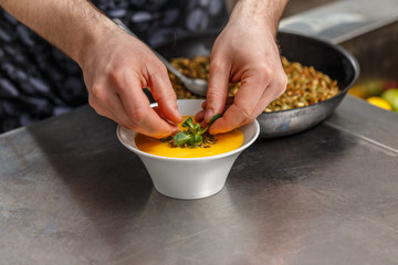 Chef decorating soup