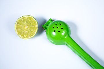 Lemon squeezer and a lime sliced in half isolated on white background