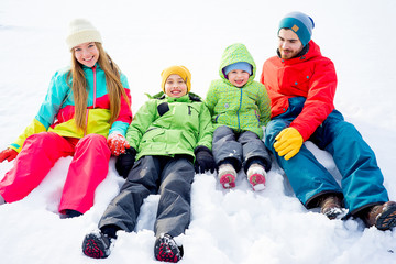Family lying in snow