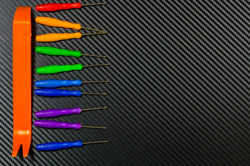 rainbow collection of screwdrivers on carbone background - obrazy, fototapety, plakaty
