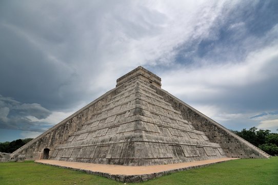 Exterior view of El Castillo pyramid against cloudy sky